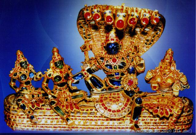 Это Божество Господа Вайкунтхи, которого сопровождают три Его главные супруги Шри-деви, Бху-деви и Дурга-деви (они же олицетворенные три главные энергии Бога). Эти Божества целиком выполнены из золота и драгоценных камней. Так Богу поклонялись в древности ведические цари, и некоторые подобные реликвии были переданы на поклонение Вадирадже его знатными учениками из царского сословия
